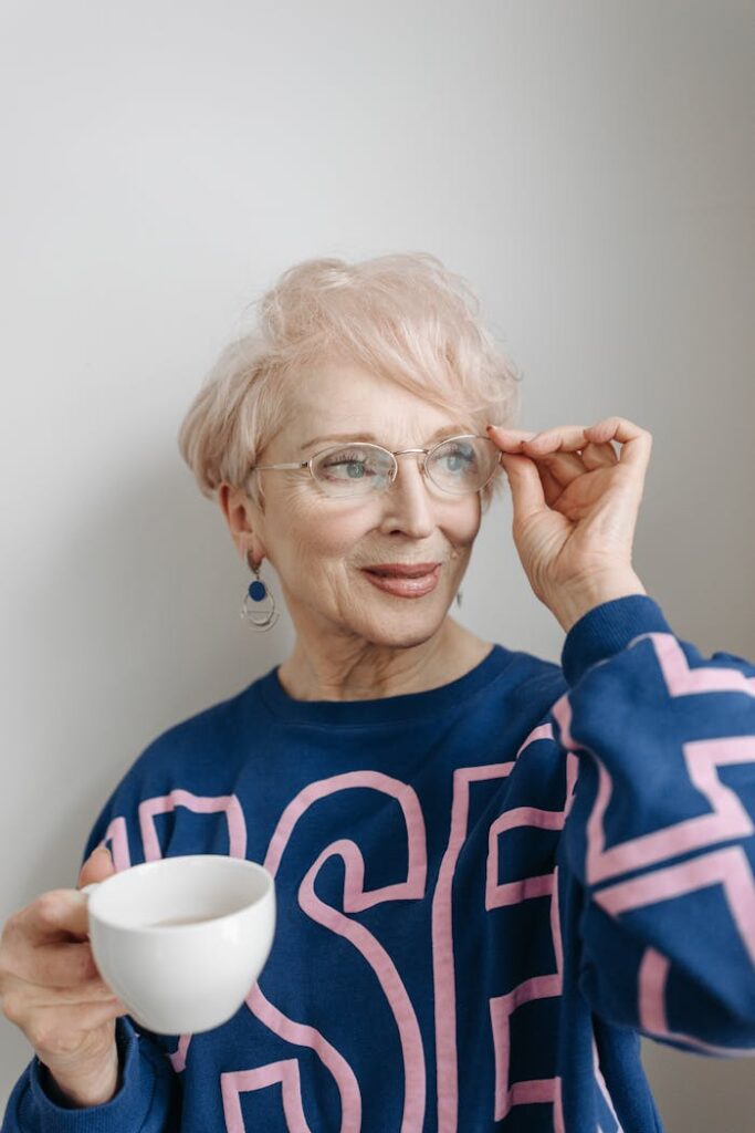 Elderly Woman in Blue Long Sleeve Shirt Wearing Eyeglasses